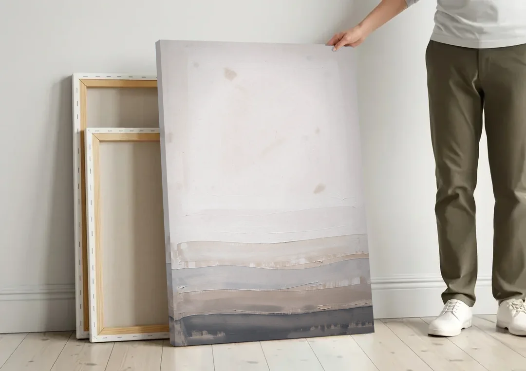Muted Abstract Wall Art of Rising Morning Haze canvas wall art leaning against a wall next to blank canvases