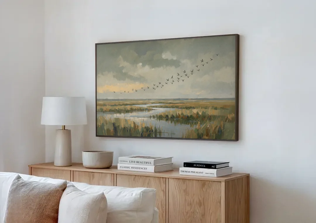 Muted Landscape with Birds Over the Reed Marsh canvas wall art above a wooden sideboard next to a sofa