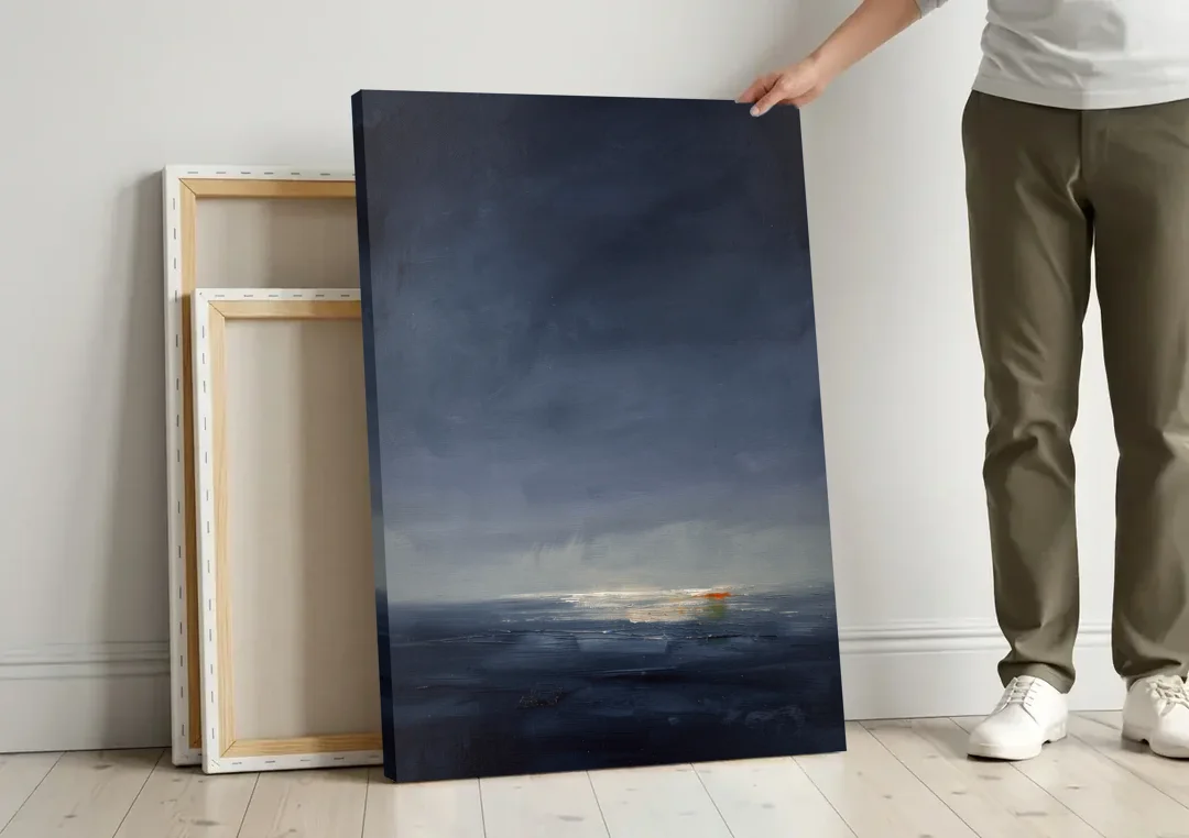 Navy Blue Abstract Wall Art with Last Light canvas wall art leaning against a wall next to blank canvases