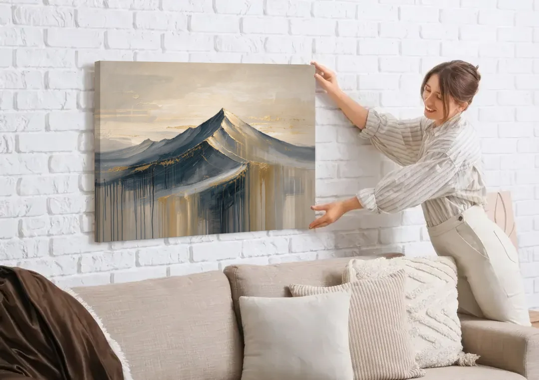 Navy Gold Abstract Painting of a Mountain Summit canvas wall art being hung on a white brick wall above a sofa