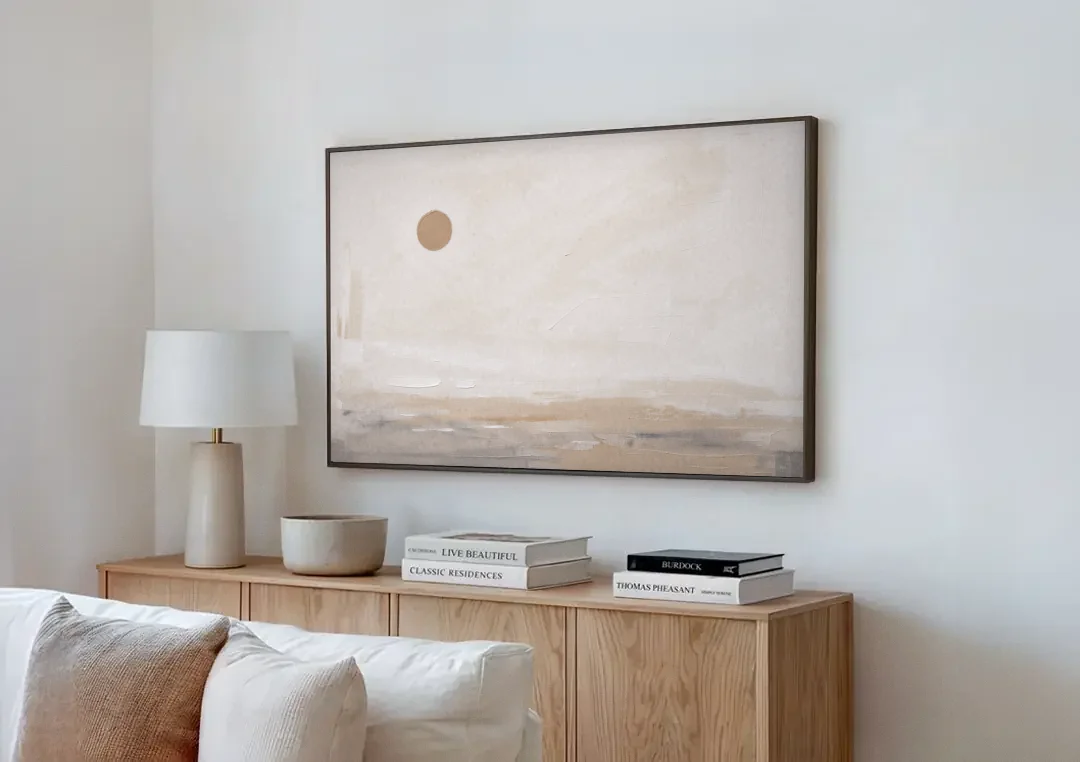 Negative Space Art with a High Clay Sun canvas wall art above a wooden sideboard next to a sofa