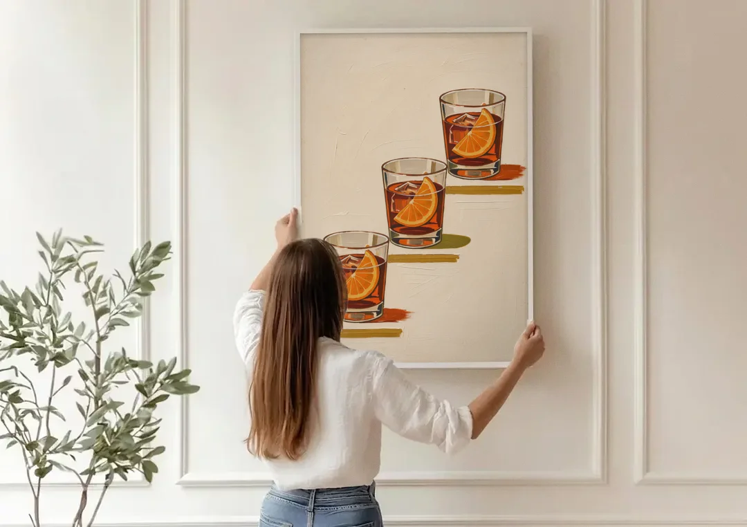 Negroni Wall Art with Three Orange Slices canvas wall art being hung on a paneled wall
