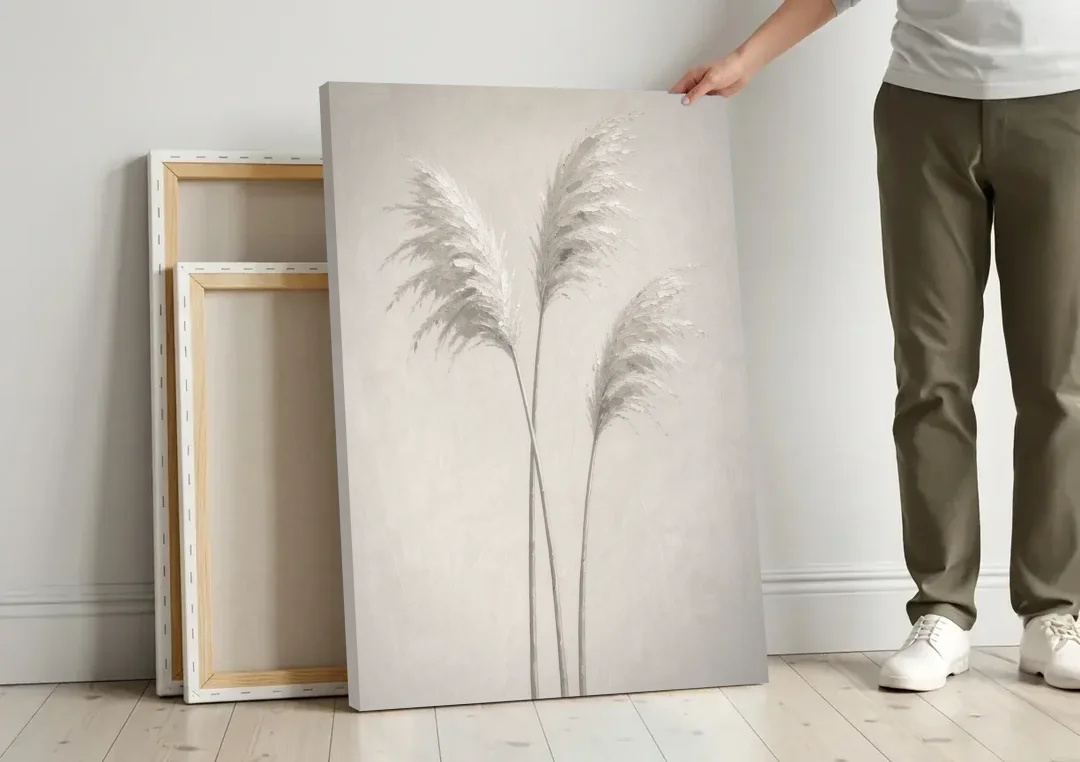 Neutral Botanical Prints of Pampas Grass Plumes canvas wall art leaning against a wall next to blank canvases