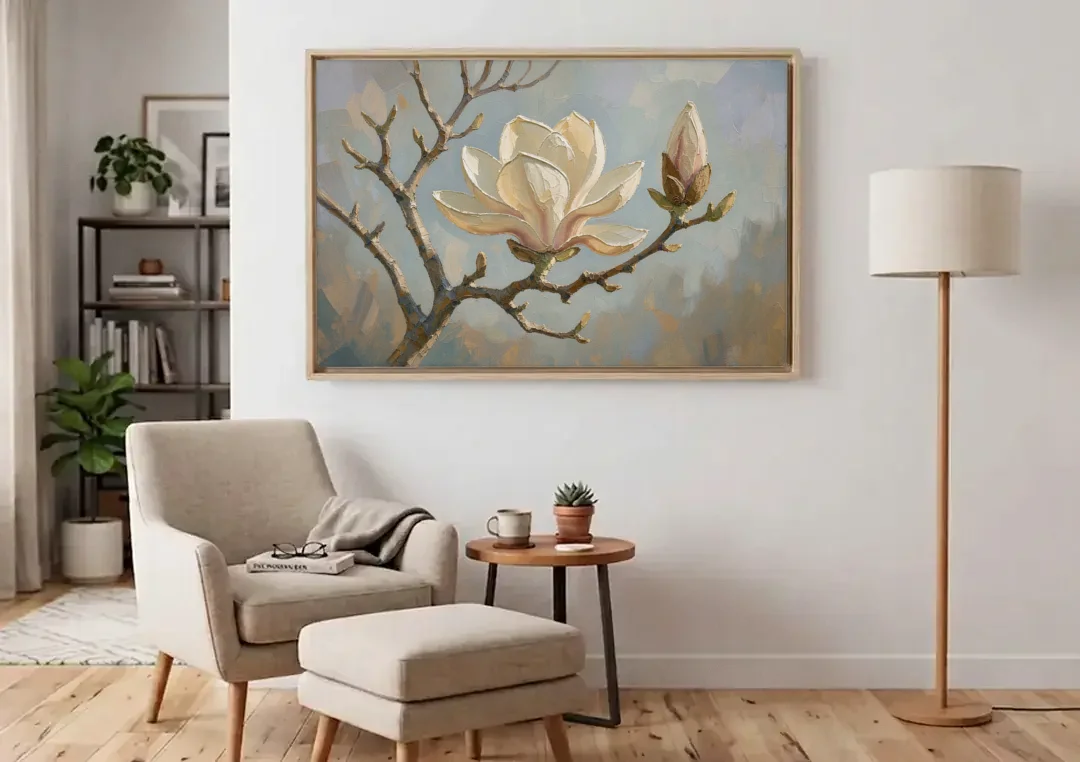 Neutral Flower Painting of a Cream Magnolia Branch canvas wall art above an armchair in a bright living room