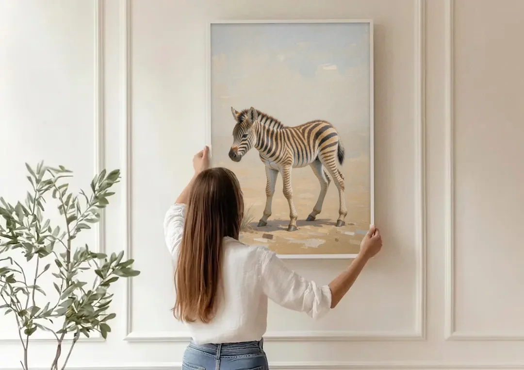 Neutral Safari Nursery Decor with a Wobbly Zebra Foal canvas wall art being hung on a paneled wall
