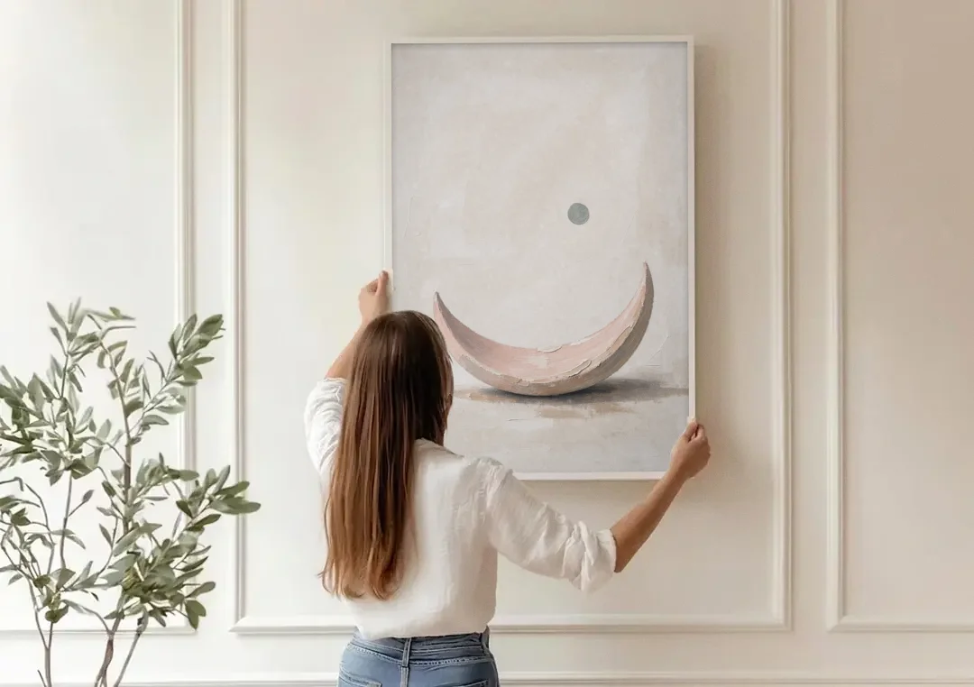 Neutral Wall Art for Bedroom with Blush Crescent Cradle canvas wall art being hung on a paneled wall