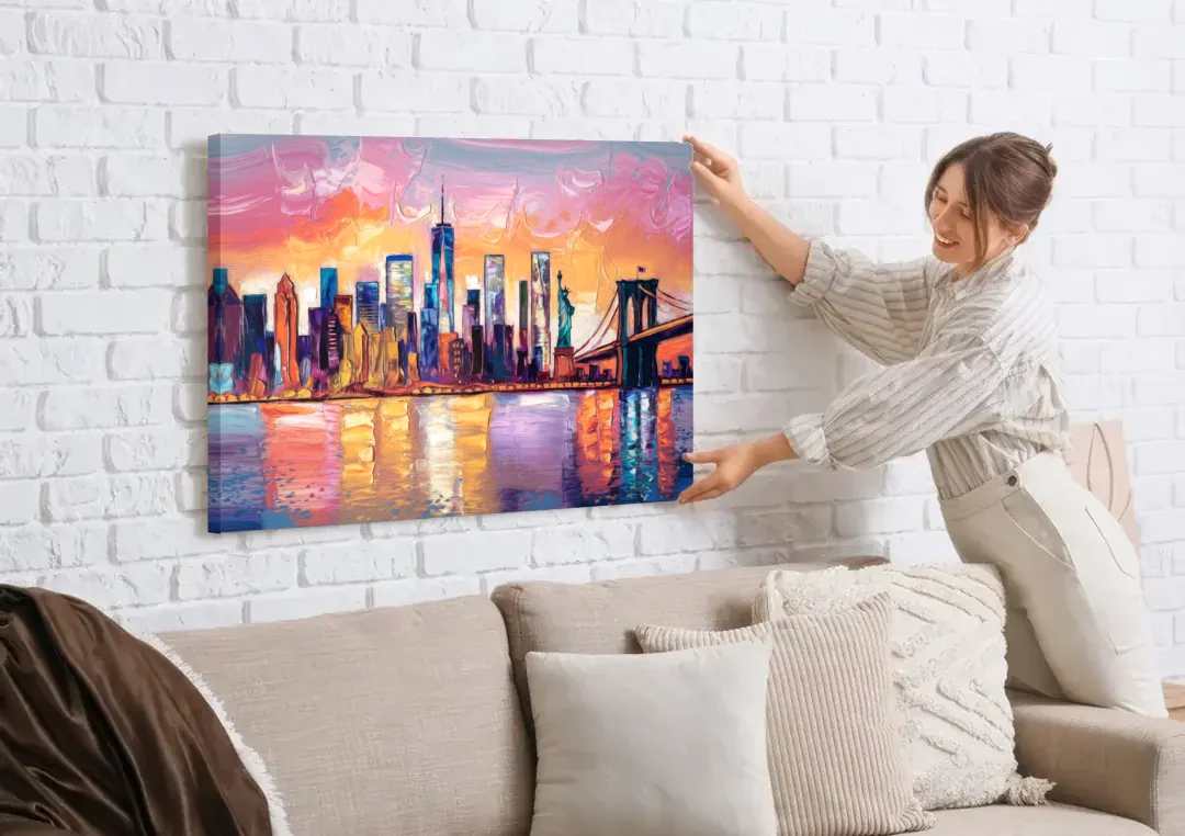 New York City Artistic Watercolor View canvas wall art being hung on a white brick wall above a sofa