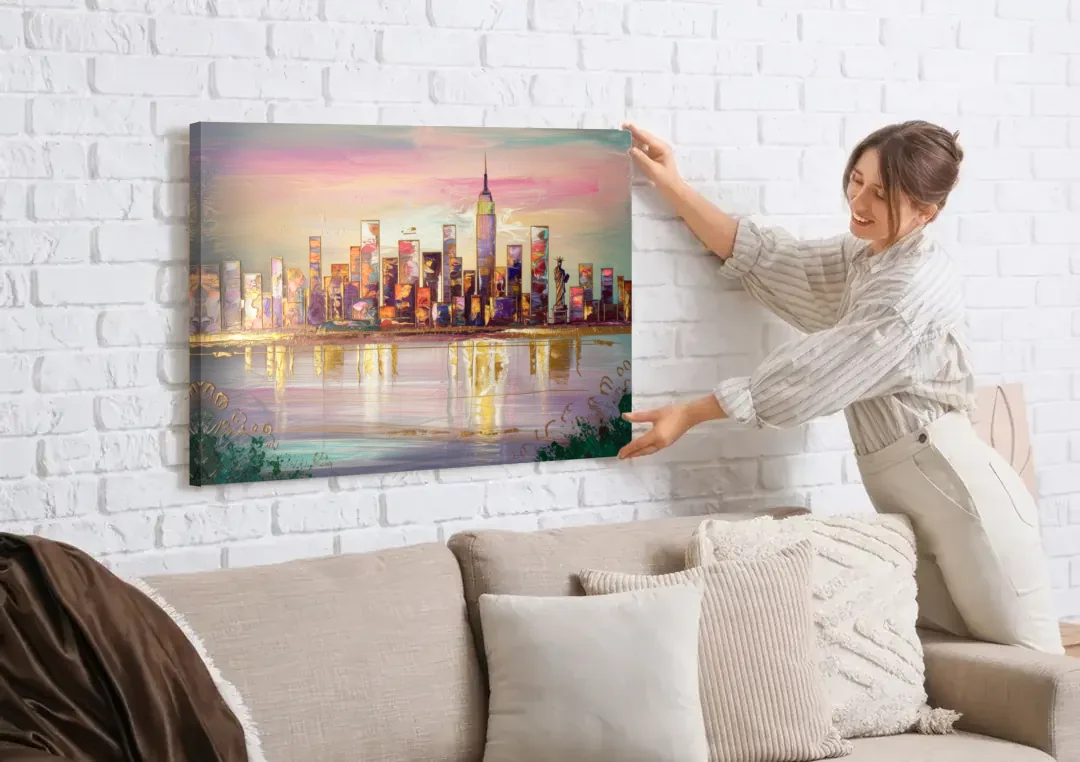 New York City Downtown Skyline canvas wall art being hung on a white brick wall above a sofa