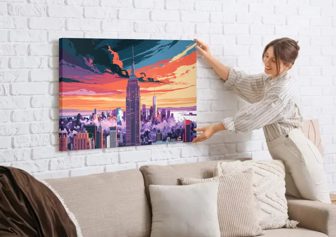 New York City Empire State Building canvas wall art being hung on a white brick wall above a sofa