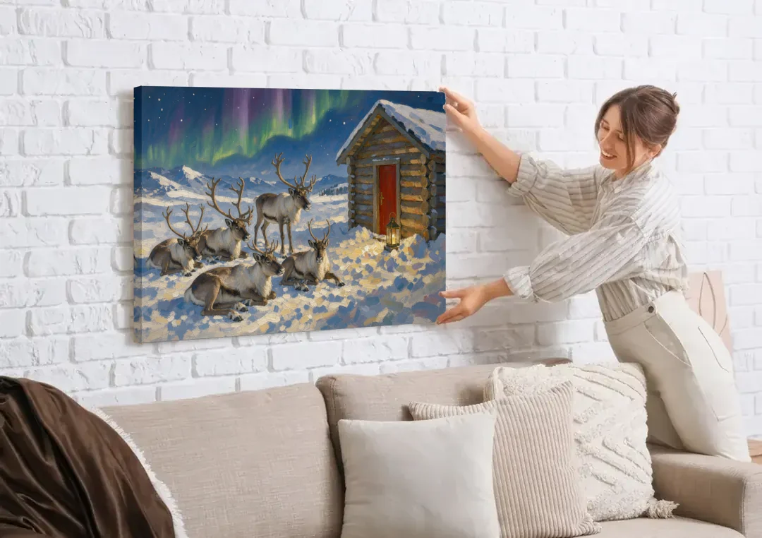 North Pole Wall Art of Resting Reindeer canvas wall art being hung on a white brick wall above a sofa