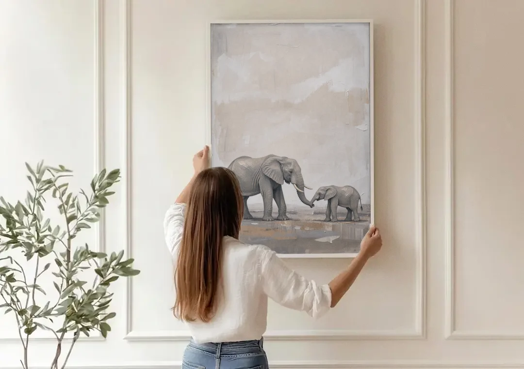 Nursery Wall Decor Above Crib with Elephant Trunks Touching canvas wall art being hung on a paneled wall