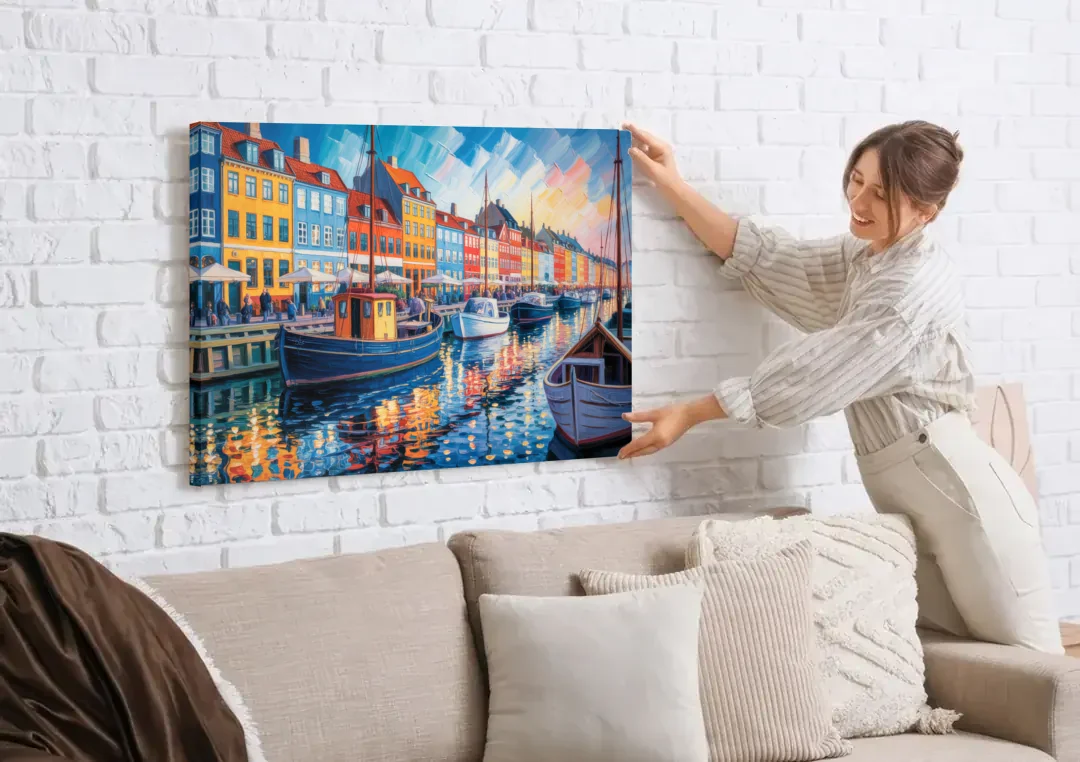Nyhavn Serenity canvas wall art being hung on a white brick wall above a sofa