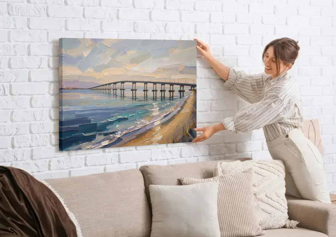 Office Canvas Wall Art of a Long Bay Bridge canvas wall art being hung on a white brick wall above a sofa