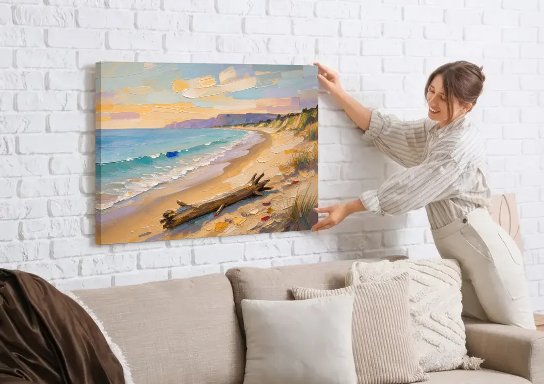 Oil Painting of Beach and Lone Driftwood canvas wall art being hung on a white brick wall above a sofa