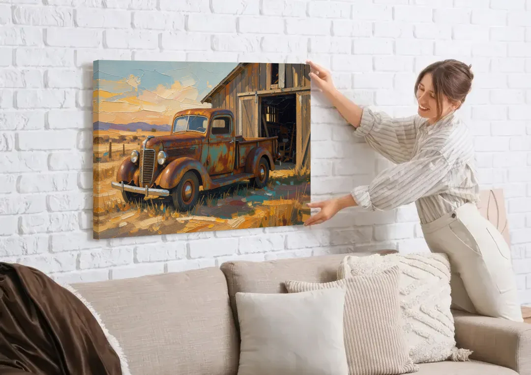 Old Truck Painting by the Weathered Barn canvas wall art being hung on a white brick wall above a sofa