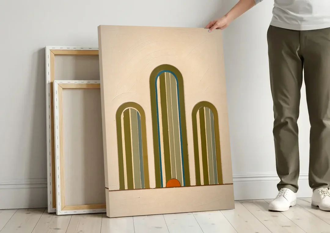 Olive Green Wall Art with Three Striped Arches canvas wall art leaning against a wall next to blank canvases