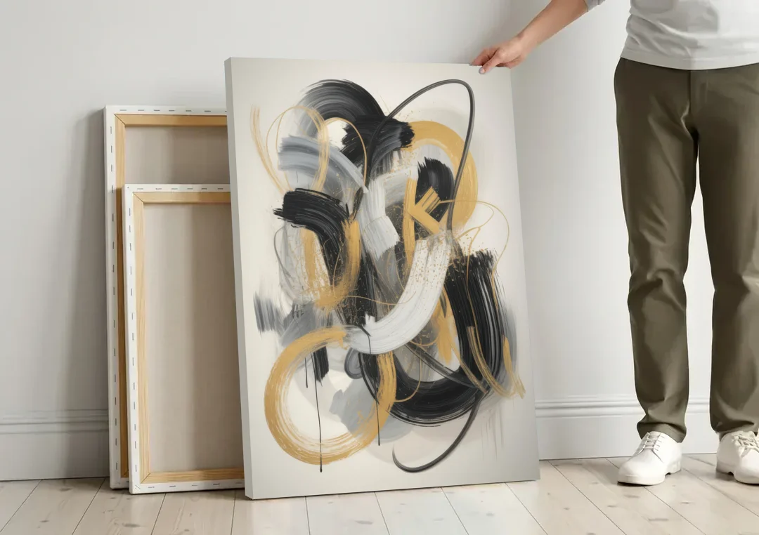 Opulent Movement Black White and Gold Abstract canvas wall art leaning against a wall next to blank canvases