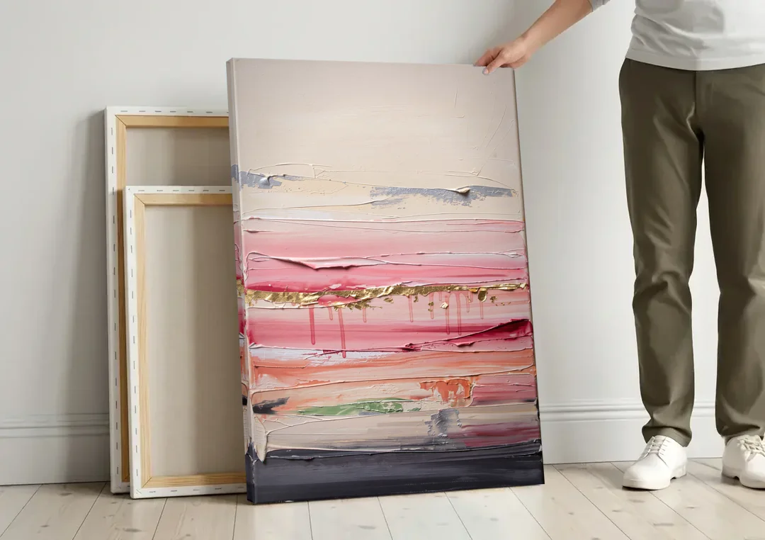 Opulent Serenity Pink and Gold Abstract canvas wall art leaning against a wall next to blank canvases