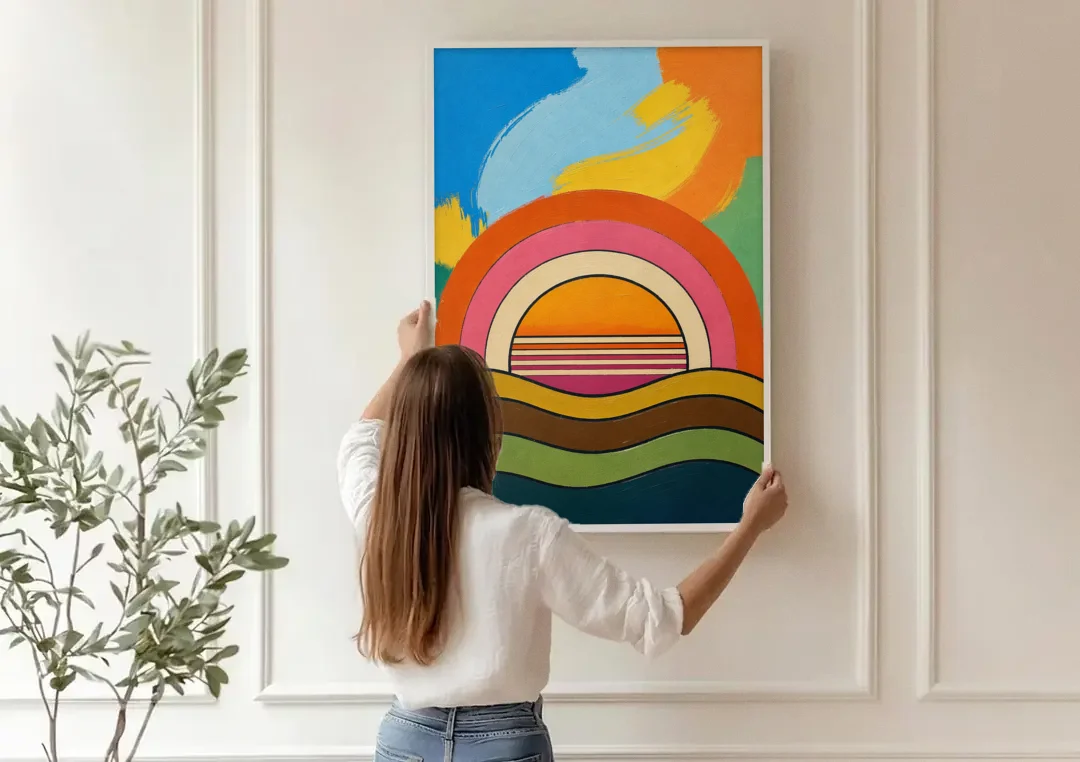 Orange and Pink Wall Art with a Rainbow Sun canvas wall art being hung on a paneled wall