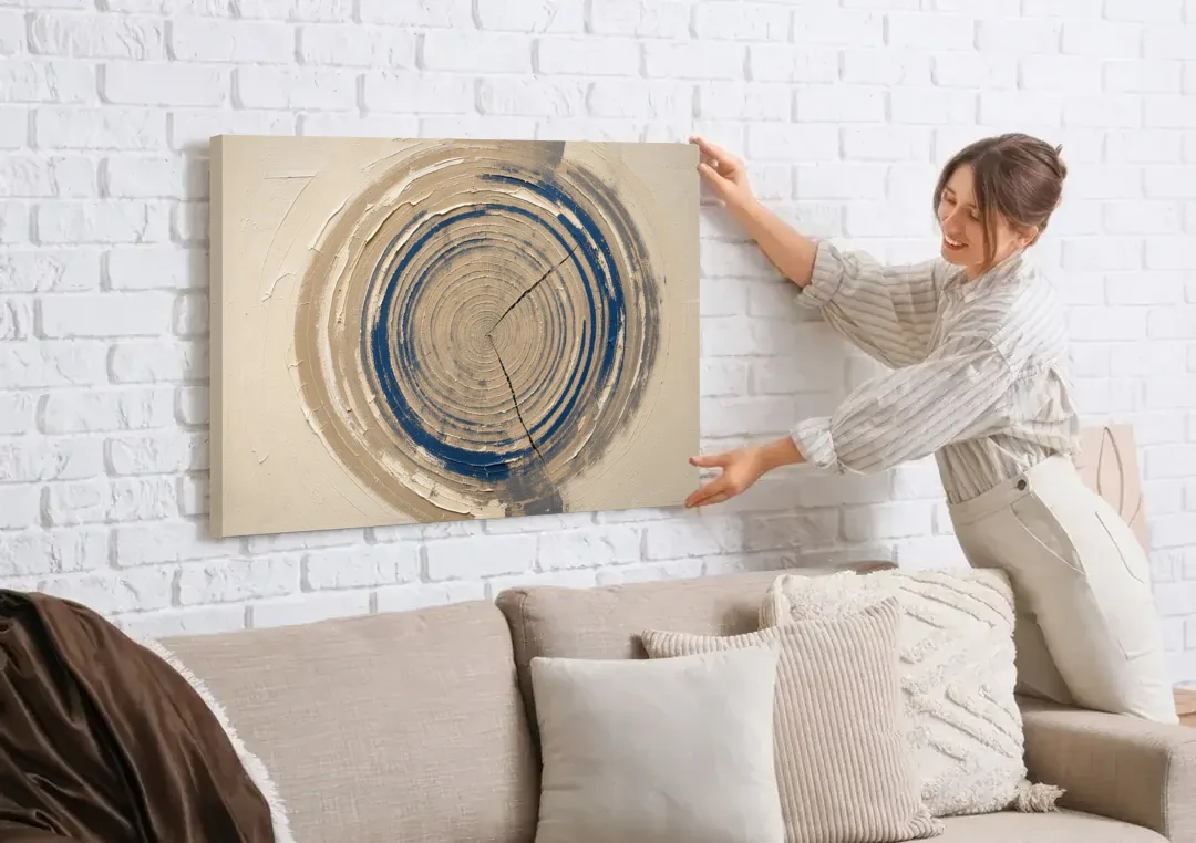 Organic Abstract Wall Art of Navy Tree Rings canvas wall art being hung on a white brick wall above a sofa
