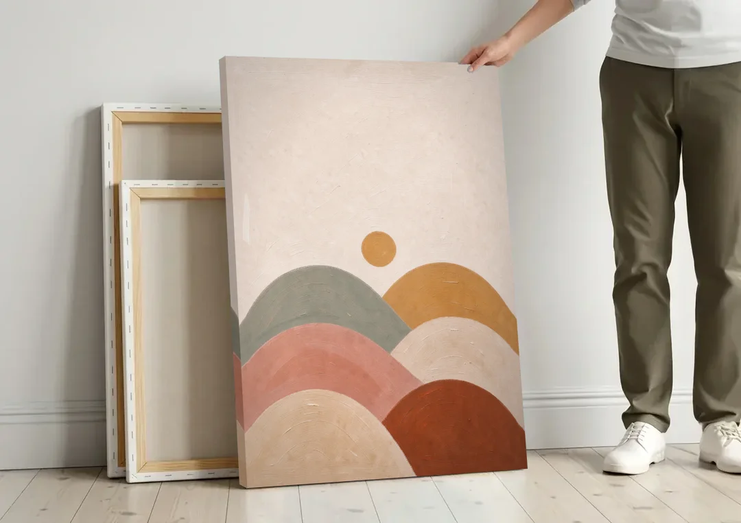 Overlapping Scalloped Hills Under a Small Sun canvas wall art leaning against a wall next to blank canvases