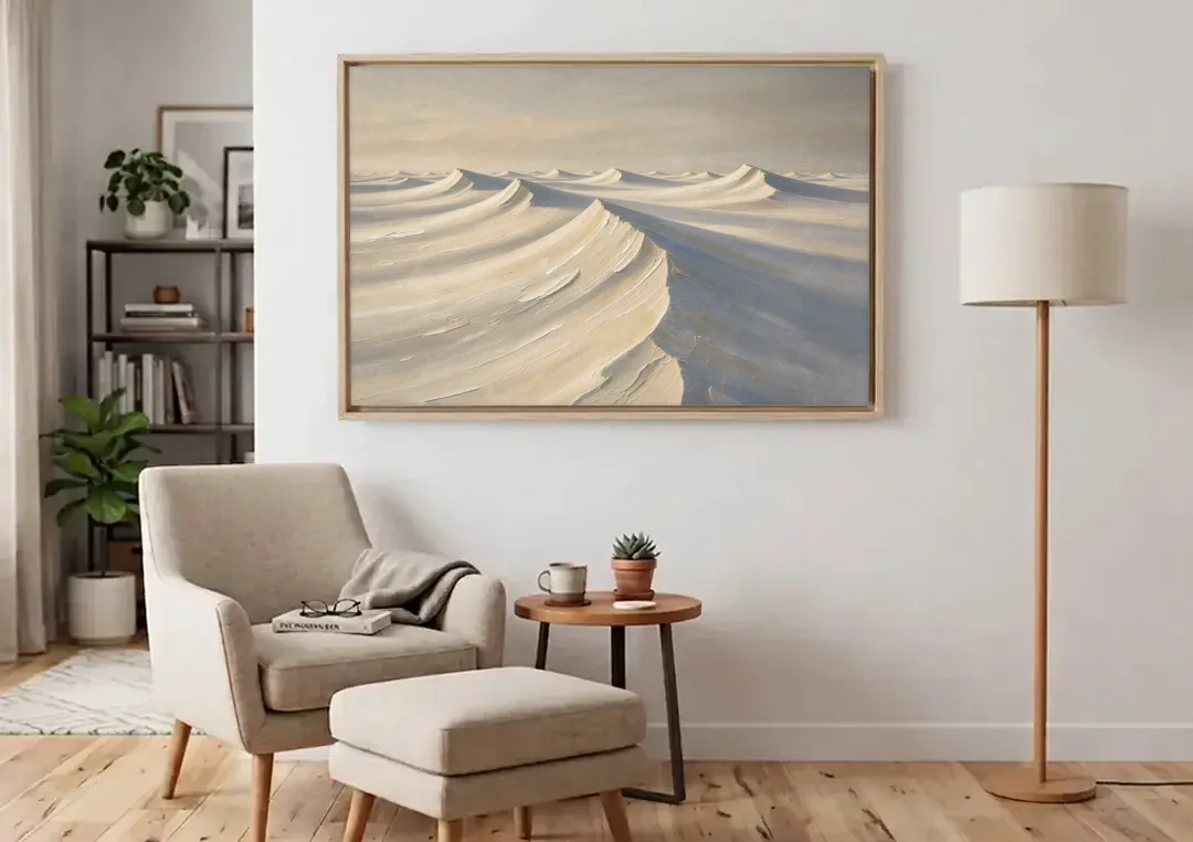 Oversized Neutral Wall Art of Curling Snow Drifts canvas wall art above an armchair in a bright living room
