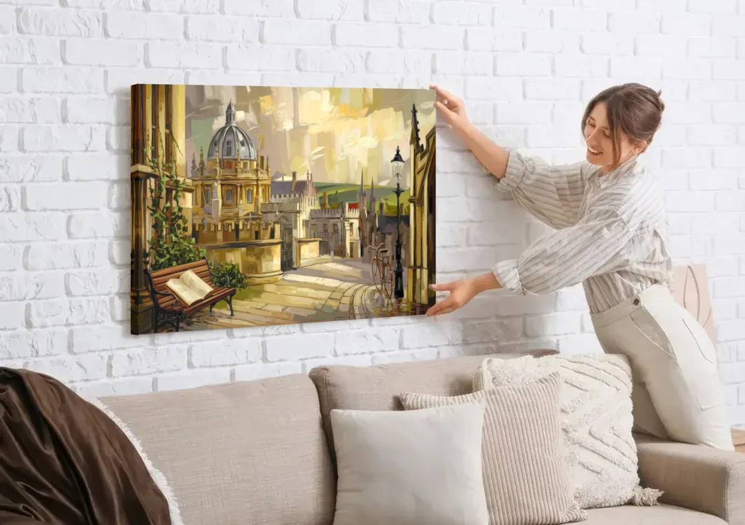Oxford University Charm canvas wall art being hung on a white brick wall above a sofa
