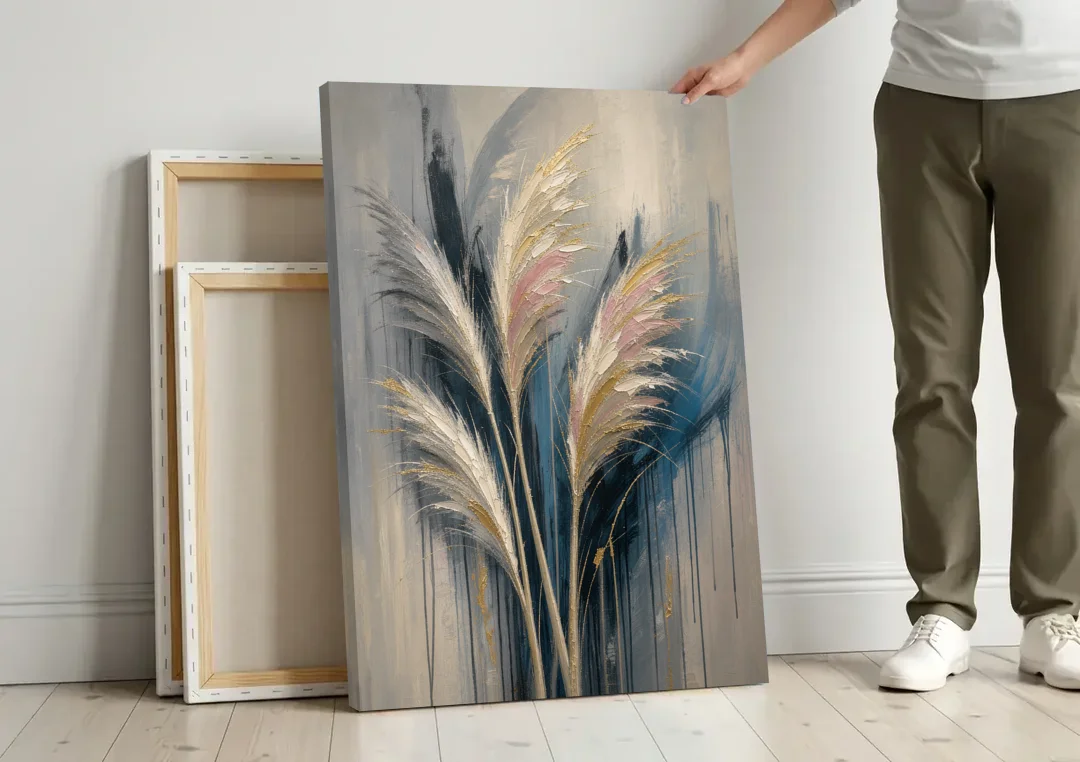 Pampas Grass Canvas with Rose and Gold Plumes canvas wall art leaning against a wall next to blank canvases