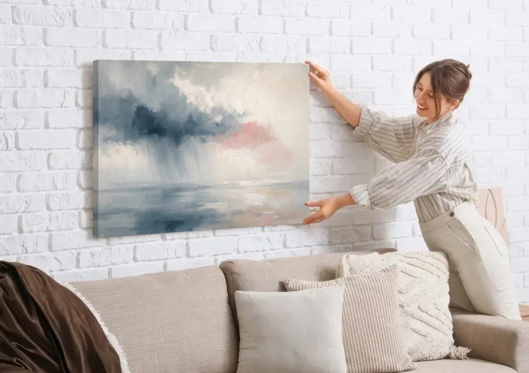 Passing Rain Over a Calm Sea Above the Headboard canvas wall art being hung on a white brick wall above a sofa