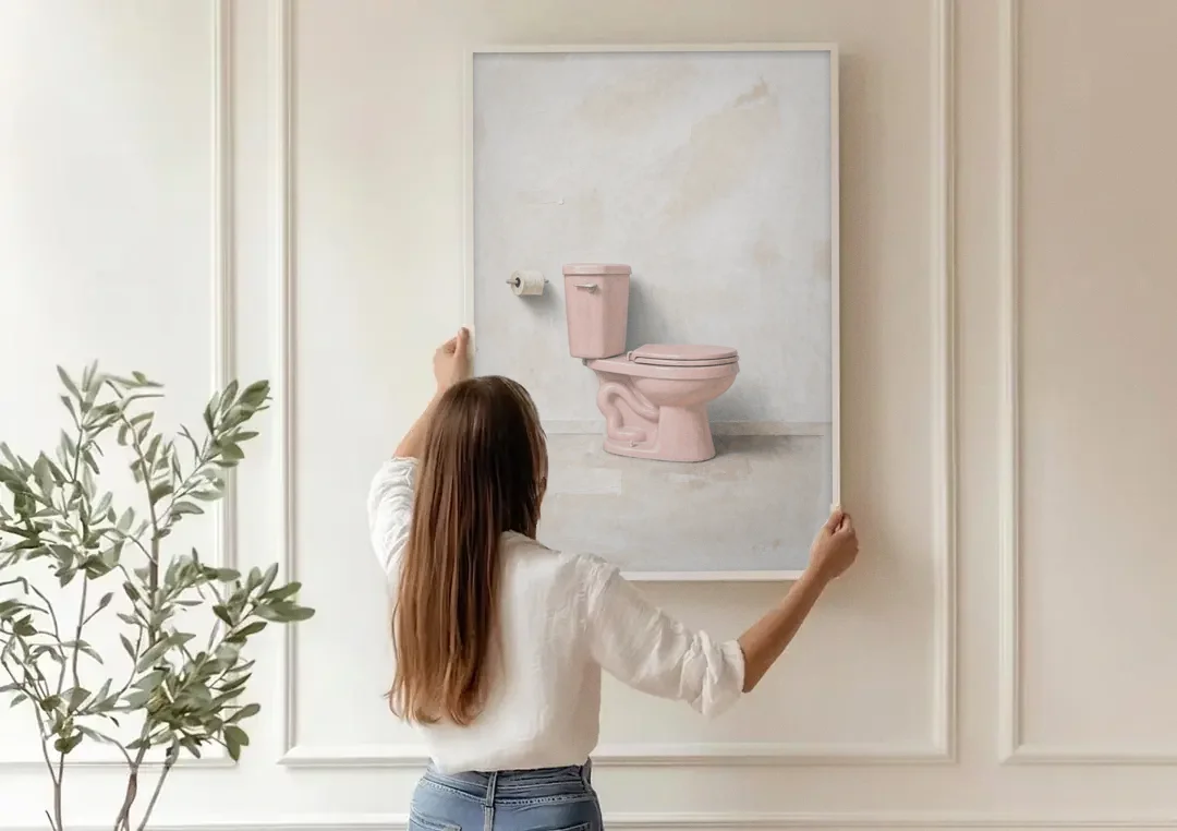 Pastel Bathroom Decor with a Pink Toilet in Profile canvas wall art being hung on a paneled wall