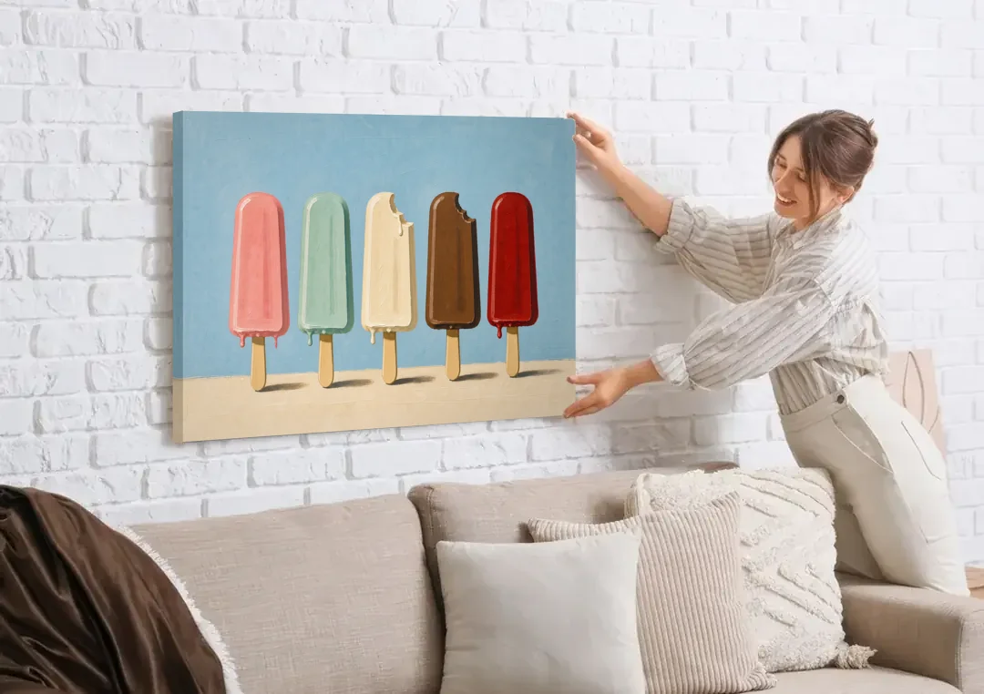Pastel Wall Art with Five Popsicles in a Row canvas wall art being hung on a white brick wall above a sofa