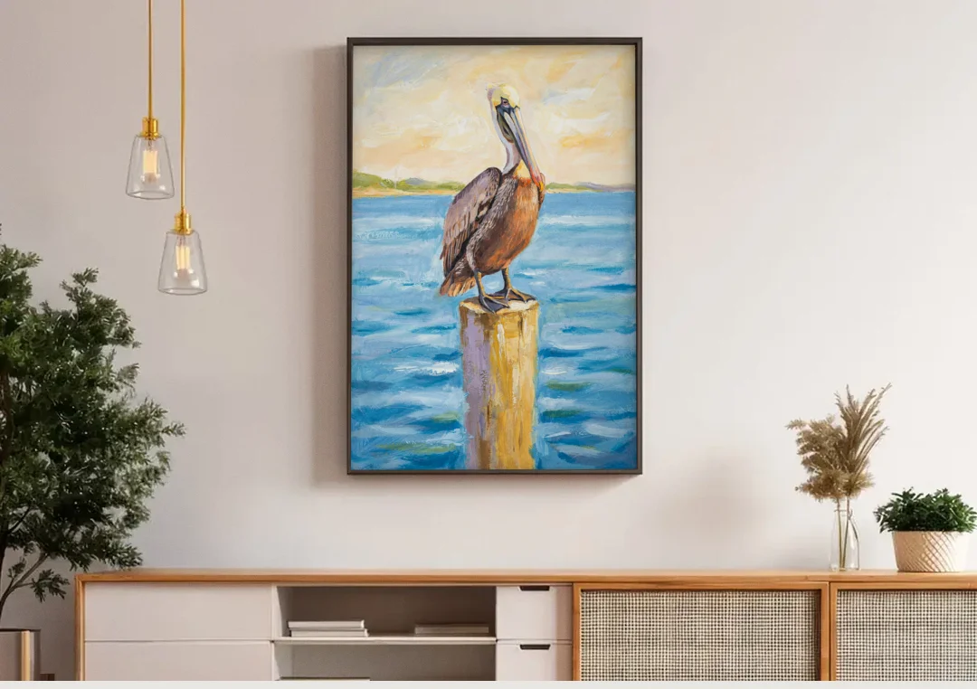 Pelican Painting on the Morning Piling canvas wall art above a wooden sideboard under pendant lights