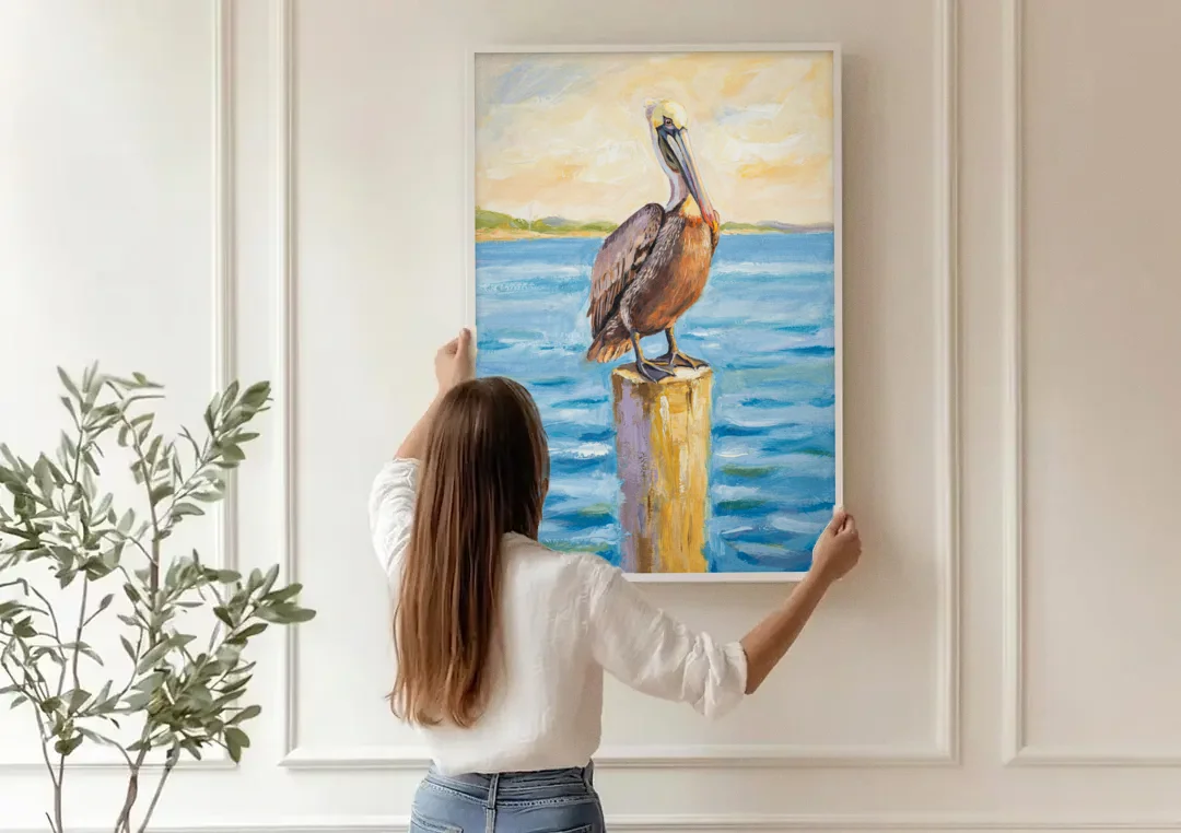 Pelican Painting on the Morning Piling canvas wall art being hung on a paneled wall