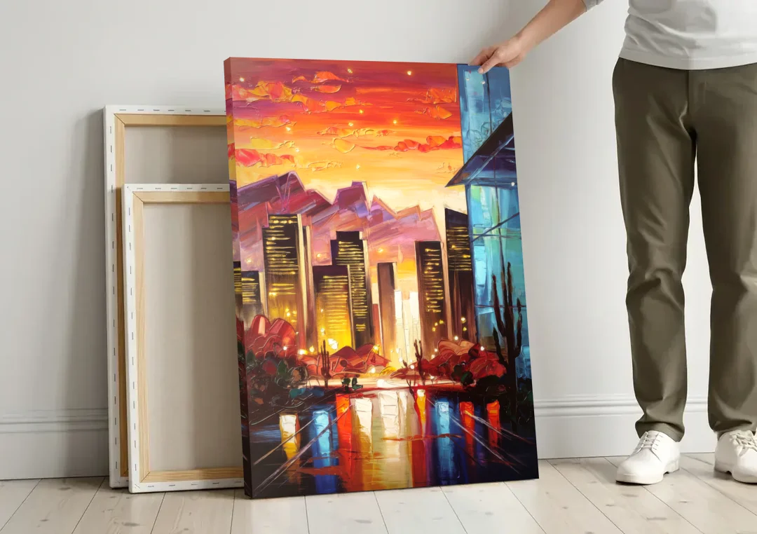 Phoenix Sunsets Over the City canvas wall art leaning against a wall next to blank canvases