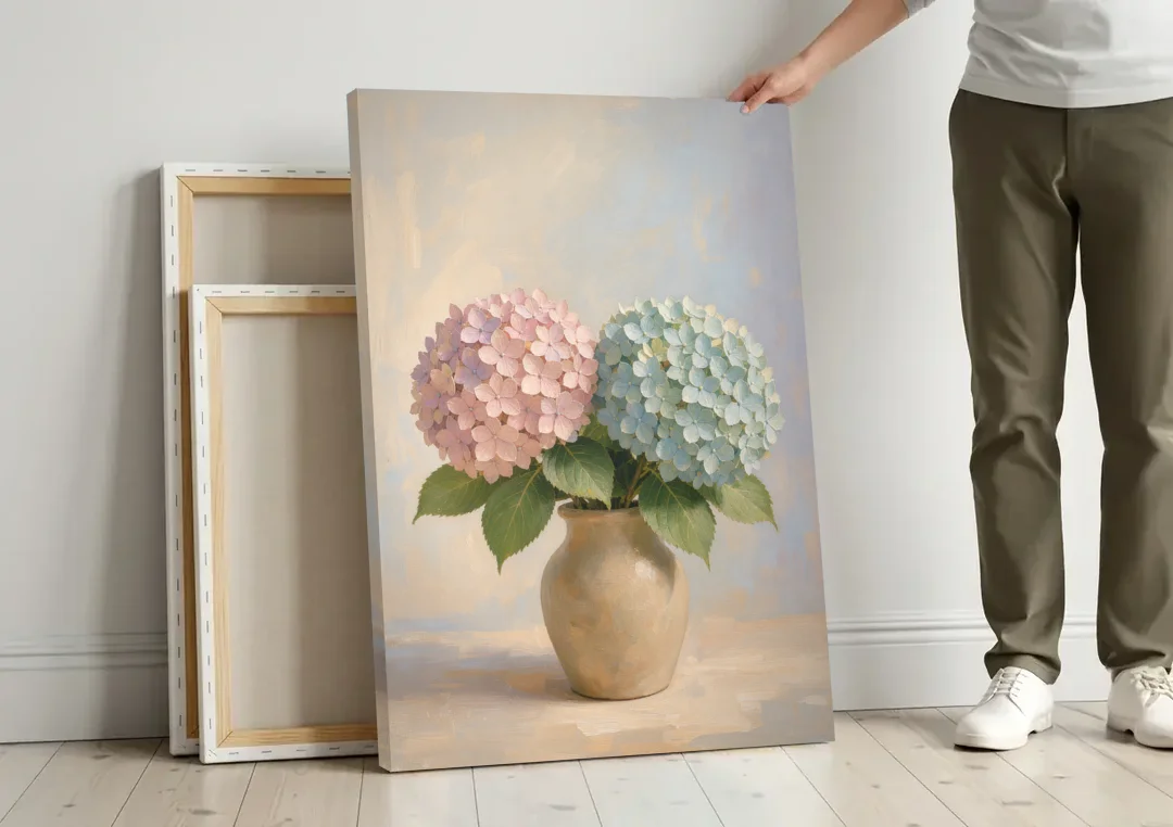 Pink and Blue Hydrangeas in a Sand Vase canvas wall art leaning against a wall next to blank canvases