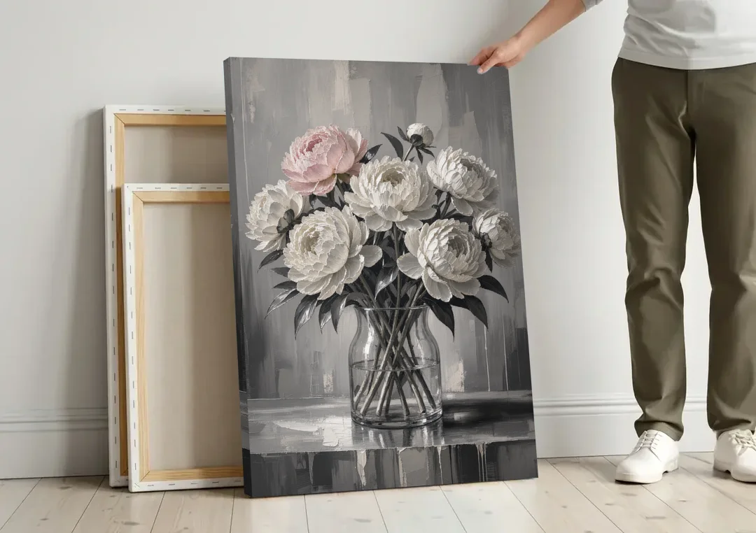 Pink Black and White Wall Art of Peonies canvas wall art leaning against a wall next to blank canvases