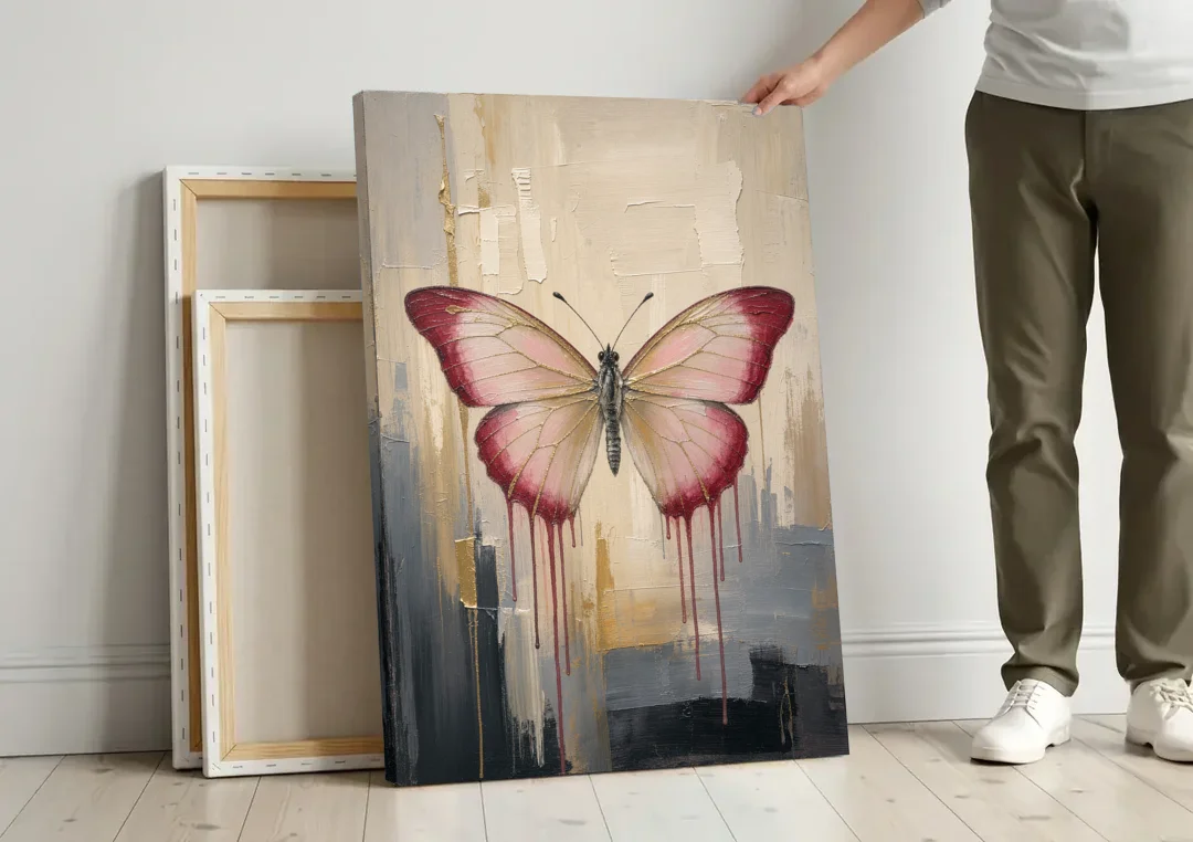Pink Butterfly with Crimson Drips canvas wall art leaning against a wall next to blank canvases