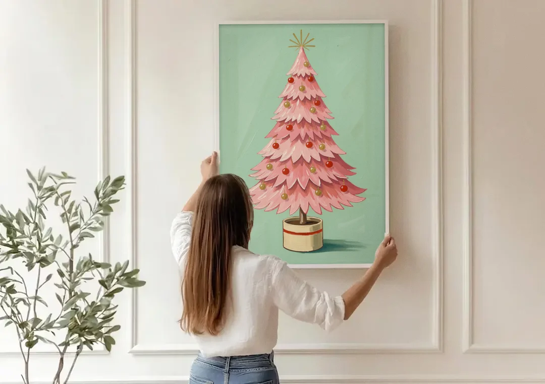 Pink Christmas Tree Painting in a Cream Drum Pot canvas wall art being hung on a paneled wall