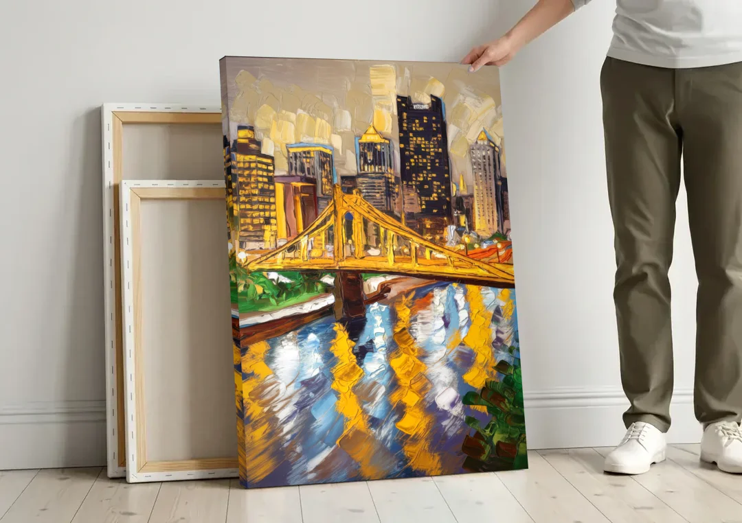 Pittsburgh Downtown Lights canvas wall art leaning against a wall next to blank canvases