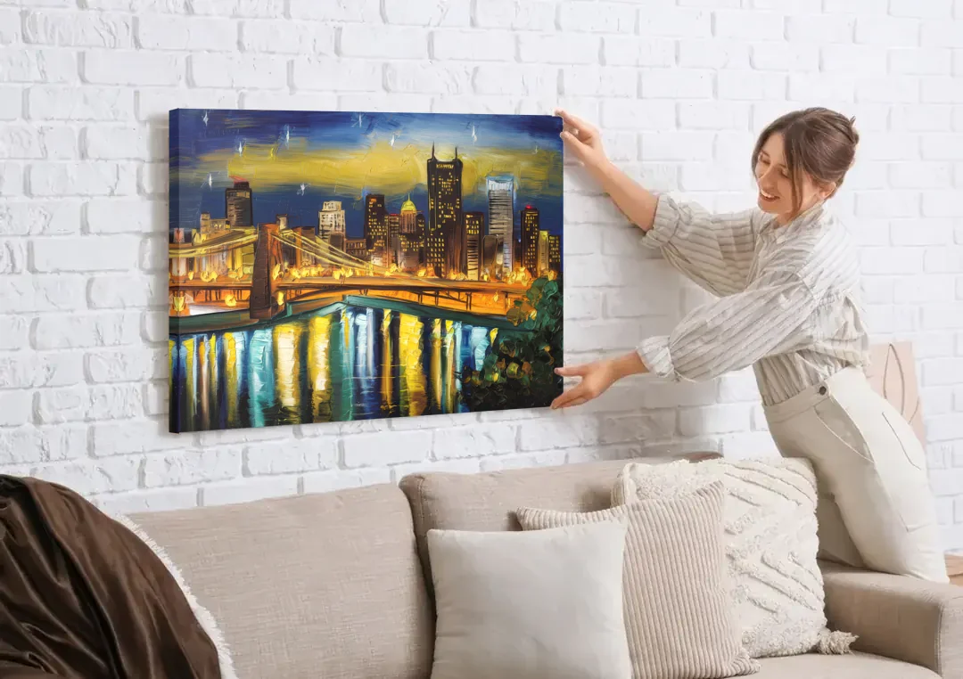 Pittsburgh Skyline With Rivers canvas wall art being hung on a white brick wall above a sofa
