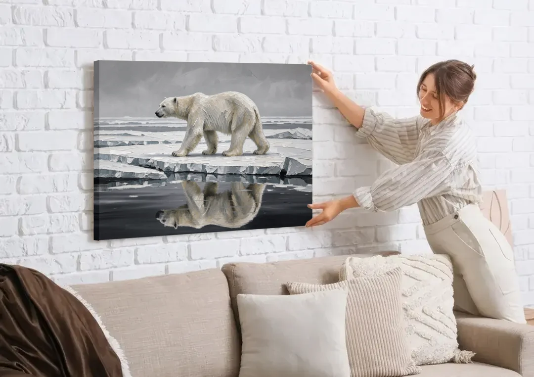 Black and White Polar Bear on Broken Sea Ice canvas wall art being hung on a white brick wall above a sofa