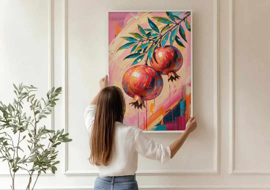 Pomegranate Painting with Two Fruits on Pink canvas wall art being hung on a paneled wall