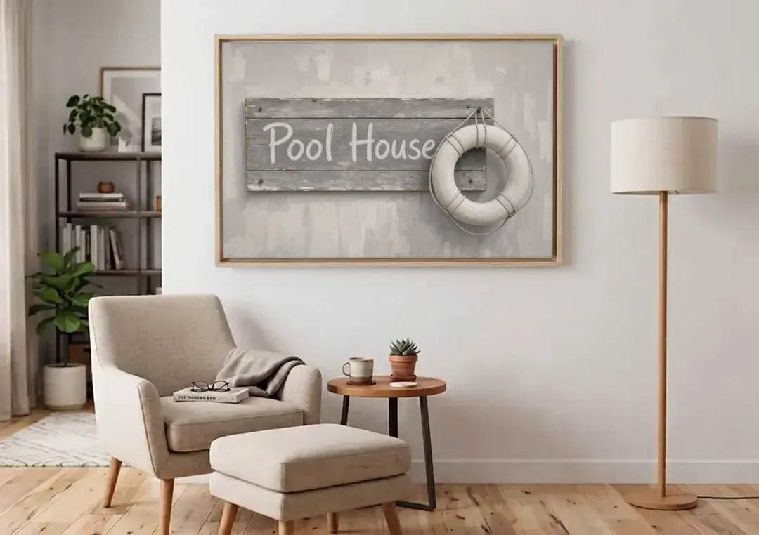 Pool House Sign with White Life Ring canvas wall art above an armchair in a bright living room