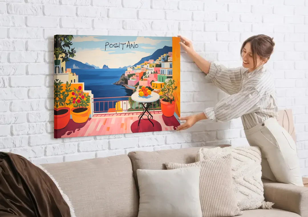 Positano Art of a Sunny Terrace canvas wall art being hung on a white brick wall above a sofa