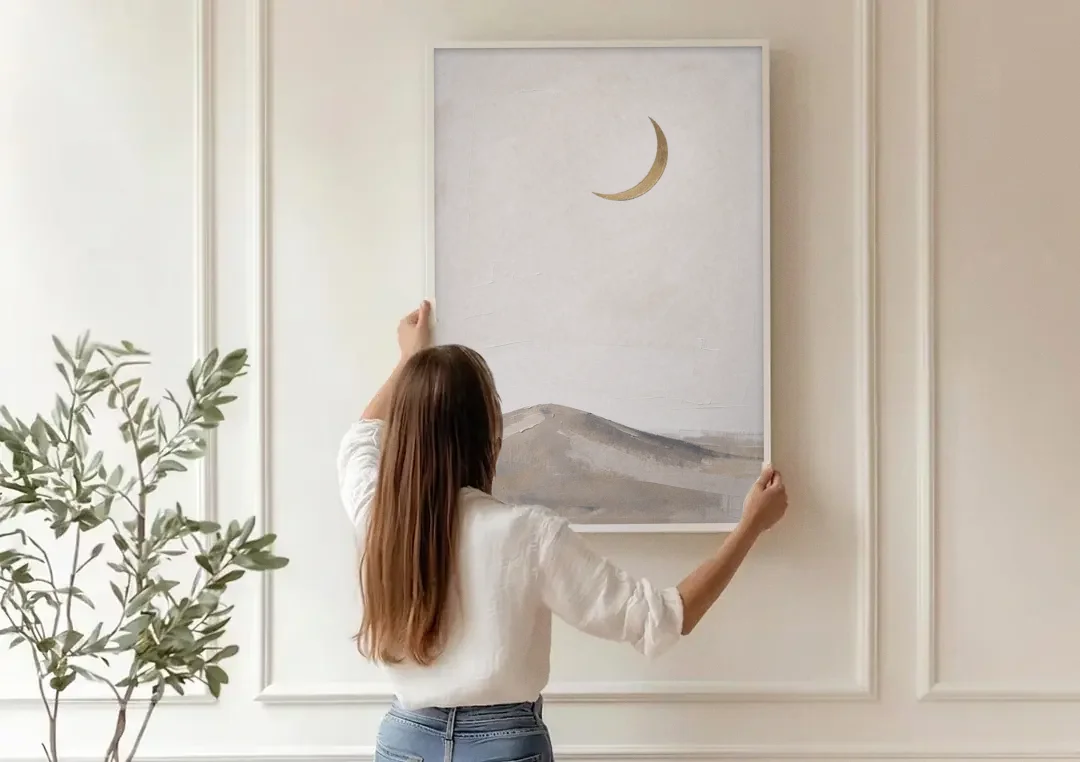 Quiet Luxury Wall Art with a Gold Crescent Moon canvas wall art being hung on a paneled wall