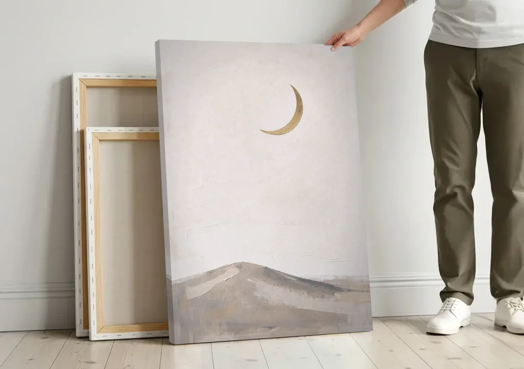 Quiet Luxury Wall Art with a Gold Crescent Moon canvas wall art leaning against a wall next to blank canvases