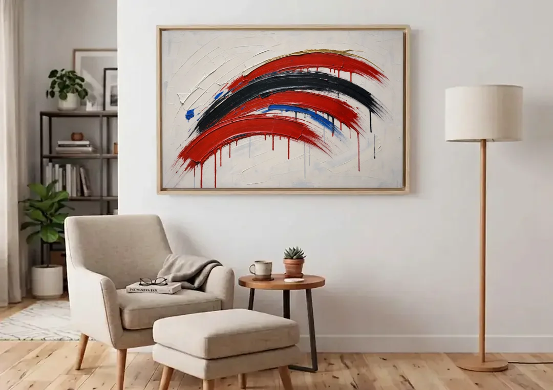 Red and Black Wall Art of Dripping Crescent Arcs canvas wall art above an armchair in a bright living room