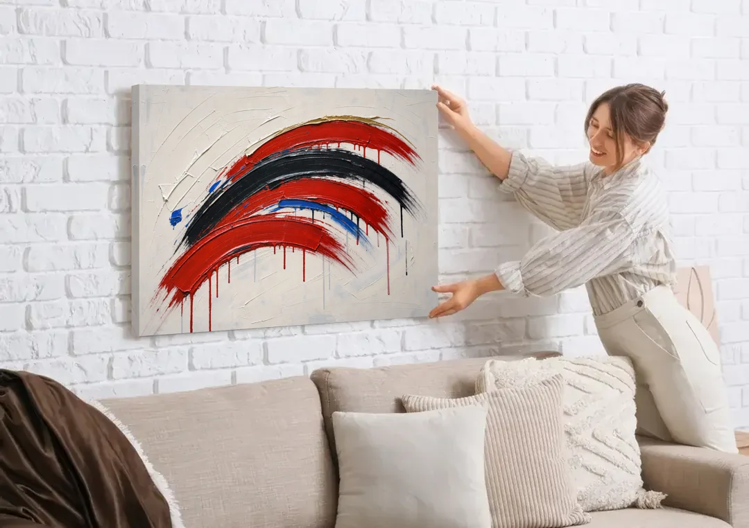 Red and Black Wall Art of Dripping Crescent Arcs canvas wall art being hung on a white brick wall above a sofa