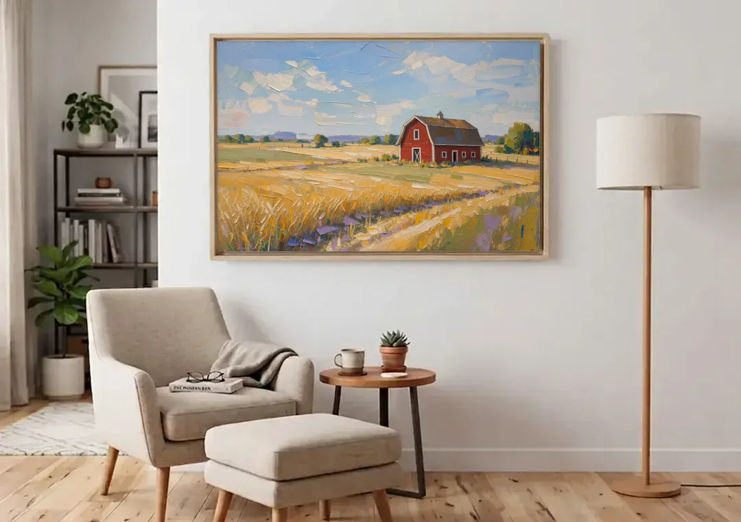 Red Barn Across Golden Grain Fields canvas wall art above an armchair in a bright living room