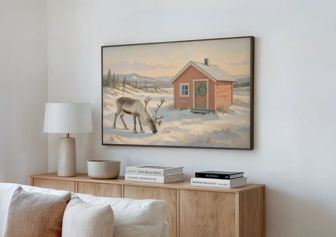 Reindeer Grazing by a Red Nordic Cabin canvas wall art above a wooden sideboard next to a sofa